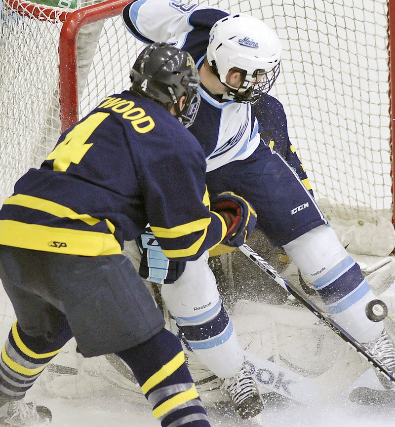 Spencer Abbott of Maine gets between Merrimack defenseman Jordan Heywood (4) and goalie Joe Cannata in the Hocky East playoff game Friday in Orono.