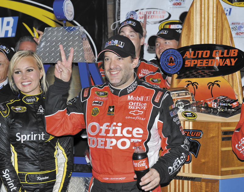 THAT’S 2: Tony Stewart celebrates after winning the rain-shortened NASCAR Sprint Cup Auto Club 400 on Sunday in Fontana, Calif. Auto Club 400