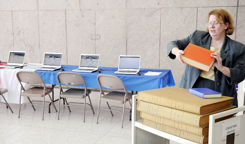 Peggy O’Kane arranges a volume Monday of Maine periodicals from the 1940s while unveiling the 1940 Census at the Maine State Library in Augusta. A survey of residents is conducted every 10 years, but the detailed information is embargoed for 72 years to protect the identity of citizens. O’Kane, the coordinator of reference and research at the state library, provided a bank of computers to teach people how to research their ancestors.ancestors during a ceremony at the Library.