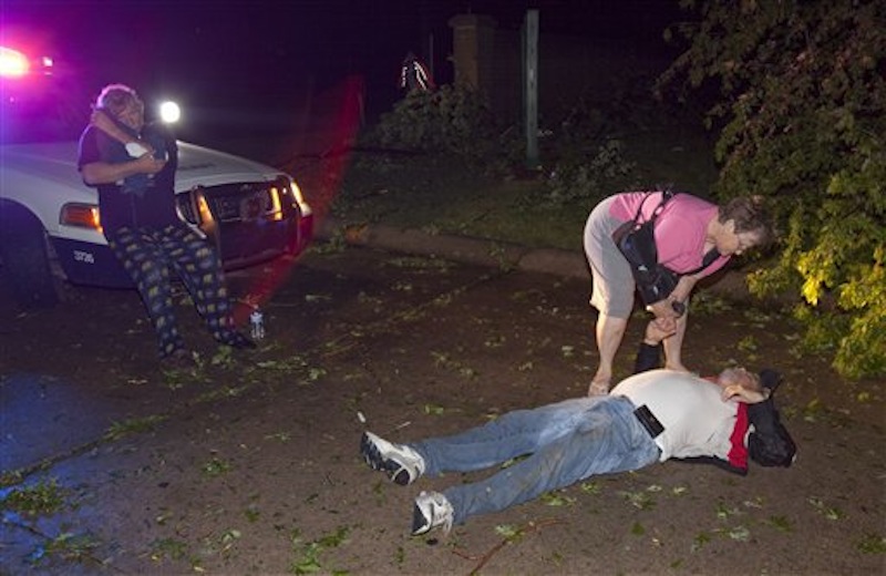 Injured people gather at the entrance to a mobile home park in Wichita, Kan., after a tornado caused massive destruction in the area, on Saturday, April 14, 2012. (AP Photo/The Wichita Eagle, Travis Heying)