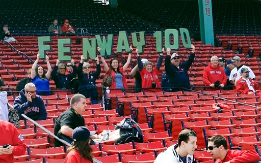 Fans hold up letters honoring the 100th anniversary of Fenway Park prior to the home opener today of the Boston Red Sox against the Tampa Bay Rays.