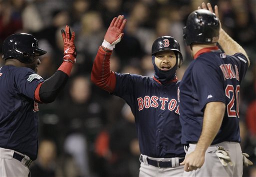 Boston Red Sox's Cody Ross, center, celebrates with Kevin Youkilis, right, and David Ortiz after scoring on a three-run double by Darnell McDonald during the sixth inning of a baseball game against the Chicago White Sox in Chicago, Friday, April 27, 2012. (AP Photo/Nam Y. Huh)