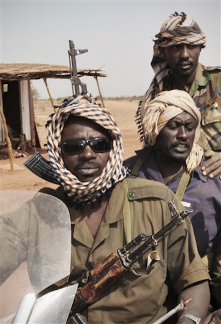 In this Wednesday, March 28, 2012 photo, Sudanese soldiers investigate the scene after South Sudan said it has pulled out its troops from a contested area along the border with Sudan shortly after clashes between the two countries' armies sparked fears of a return to war. South Sudan said Wednesday, April 4 it had shot down a Sudanese jet after its oil fields were bombed. (AP Photo)