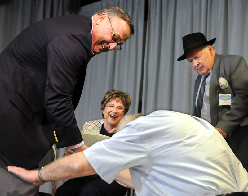 Gov. Paul LePage is greeted by Pat Thatcher as LePage, Mary Adams and John Frary take the stage Sunday at a Tax Day rally in Lewiston. Thatcher, the husband of Adams, and several other with the Tea Party/Refounders, Patriots, Constitutionalists and John Birch Society attended the event at the Franco-American Heritage Center.