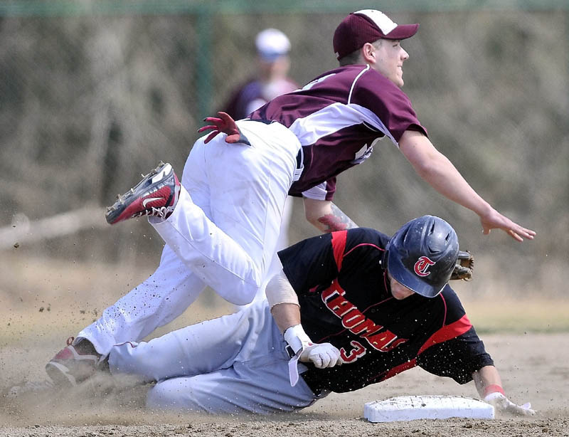 BREAK IT UP: Thomas’ Jeff Richardson slides into second base as he tries to break up the double play attempt by University of Maine at Farmington second baseman Ian McAlister in the first game of a doubleheader Wednesday in Waterville.)