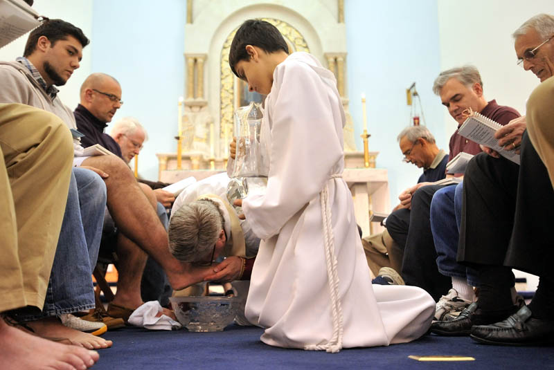 Staff Photo by Michael G. Seamans Father Larry Jensen washes and kisses the feet of 12 parishioners during the Holy Thursday service at St. Joseph's Maronite Church in Waterville Thursday evening. In the Holy Thursday service, Father Larry Jensen washed the feet of some parishiners as did Jesus and his disciples before the Last Supper.