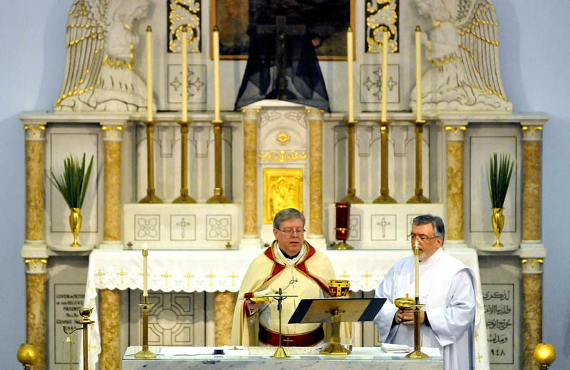 Staff Photo by Michael G. Seamans Father Larry Jensen prepares the sacrament during the Holy Thursday service at St. Joseph's Maronite Church in Waterville Thursday evening. In the Holy Thursday service, Father Larry Jensen washed the feet of some parishiners as did Jesus and his disciples before the Last Supper.