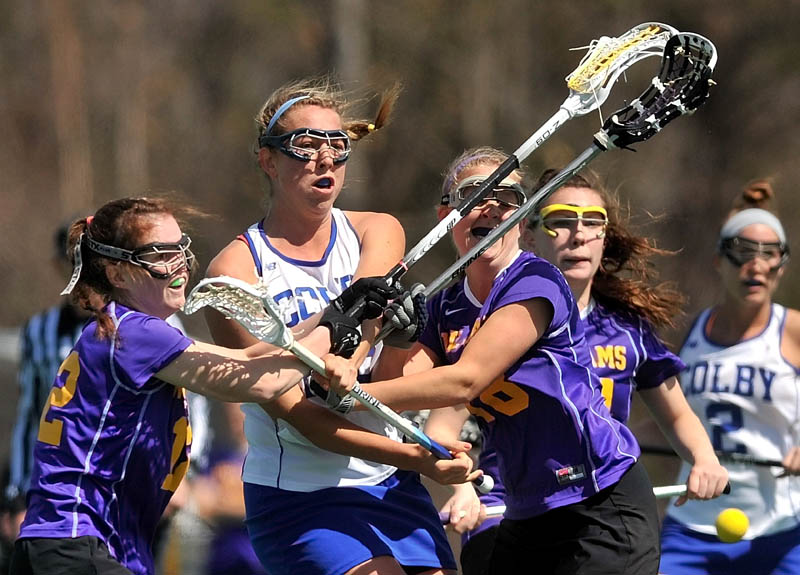 Staff Photo by Michael G. Seamans Colby College's Lindsey McKenna, 25, center left, shoots and scores as Williams College defenders, Lacey Hankin, 12, far left, and Grace Williams, 18, center, try to block the shot while Ali Pitch, 46, tries to make the save in the first period at Colby College in Waterville on Saturday.