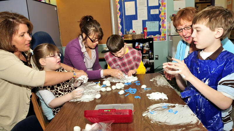 SENSORY CLASS: Winslow Elementary School education technicians work with autistic students in a special education class using a variety of sensory objects. Technicians with their respective students, from left, are Wendy Morrison with Madison Rowe, Anne Rice with Thomas Rowe and Linda Lemieux with Will Weiss.