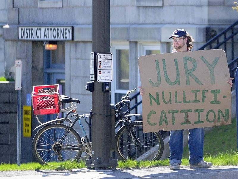 down at the courthouse: While a jury deliberates upstairs Thursday morning in the case of five protesters charged with trespassing at the Blaine House last November, Jarody — an Occupy Augusta member who uses one name — holds a sign in front of the Kennebec County Superior Court House in Augusta. A mistrial was declared later after jurors failed on several attempts to reach verdicts for the five defendants. It was not clear Thursday if there will be a retrial.