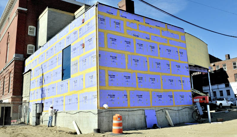 BRAVO: A worker caulks around seams on an outside wall on the renovation project on the Waterville Opera House last week.