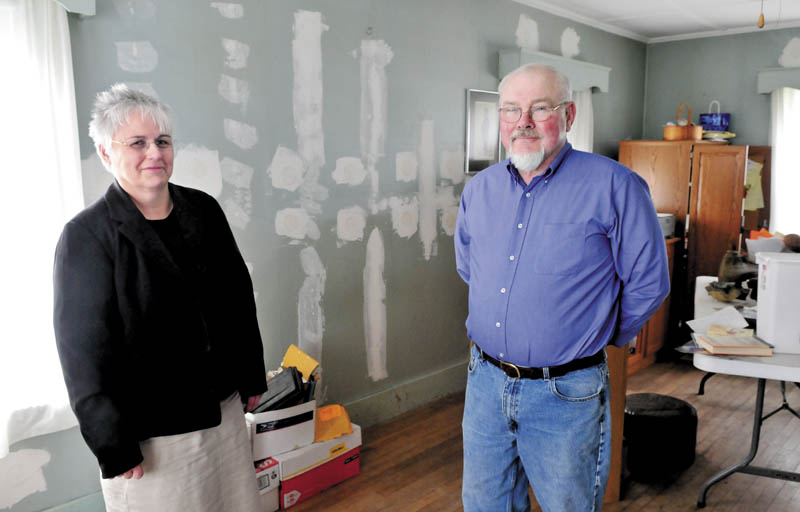 SAVERS: Sheila and John Bacon have made their Winslow home more energy efficient through a Maine Pace loan. The marks on the wall are from places where blow-in cellulose insulation was added.