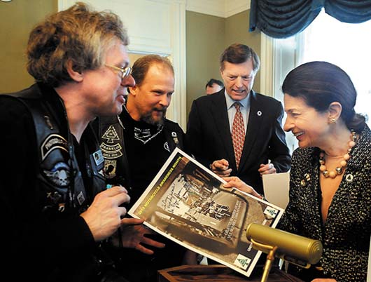 Senator Olympia Snowe (R-Maine) and her husband, former Gov. Jock McKernan, second from right, sign posters Wednesday during the United Bikers of Maine annual tea at the Blaine House in Augusta. The event was started by McKernan when he lived at the Blaine House.