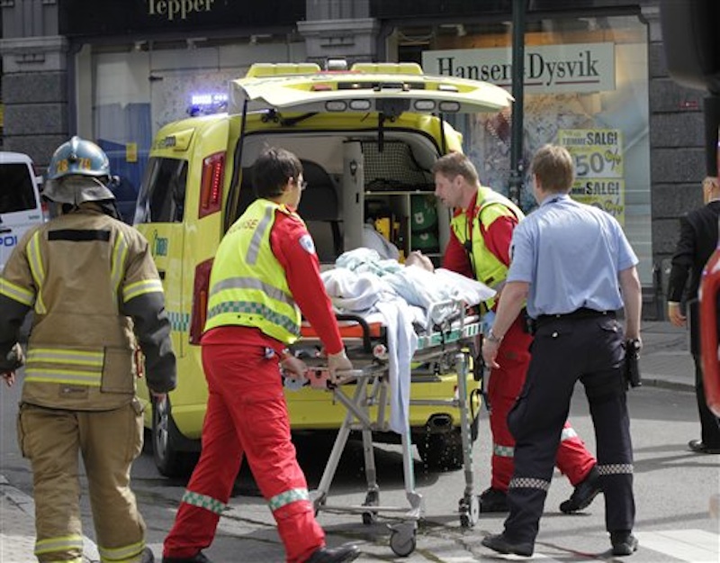 A man who set fire to himself outside the courthouse in Oslo Tuesday, May 15, 2012, where the trial of Anders Behring Breivik is taking place, is taken into an ambulance. He was overpowered by security and police personnel as he was running towards the entrance to the courthouse. He was stripped of his burning clothes and is reported to be in a serious condition. (AP Photo/Scanpix, Berit Roald) NORWAY OUT