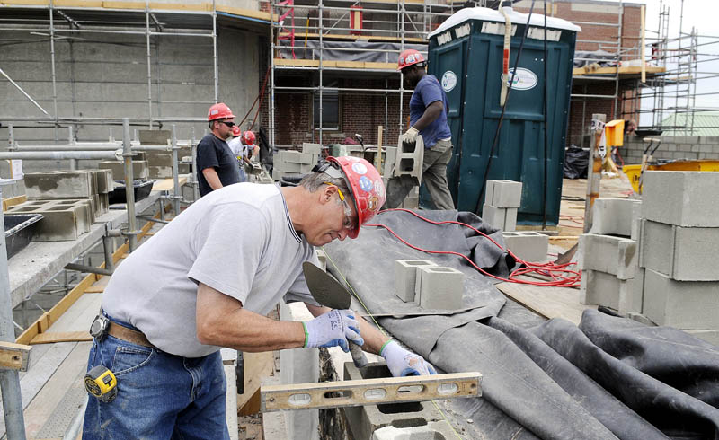 Consigli Construction mason Mike Voisine lays a concrete block Monday on the roof of the hospital at VA Maine Healthcare Systems-Togus as part of a project to repoint all the bricks on the exterior of the building.