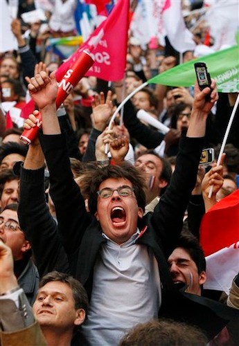A supporter of Socialist Party candidate for the presidential election Francois Hollande reacts after the first results of the second round of French presidential elections outside Socialist Party campaign headquarters in Paris, France, Sunday, May 6, 2012. First results show that Hollande had won the election. (AP Photo/Francois Mori)