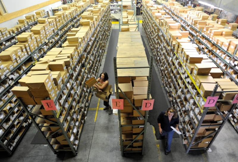 Workers at Johnny’s Selected Seeds sort packages at the shipping center in Winslow.