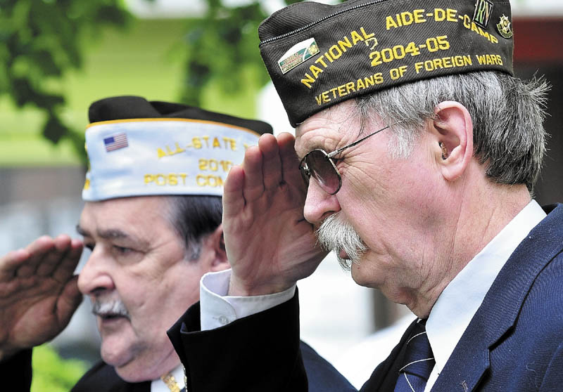 SALUTE" Veteran of Foreign Wars officers Richard Willette, left, and Charles McGillicuddy salute during one of two wreath laying ceremonies during the Memorial Day parade in Waterville on Monday.