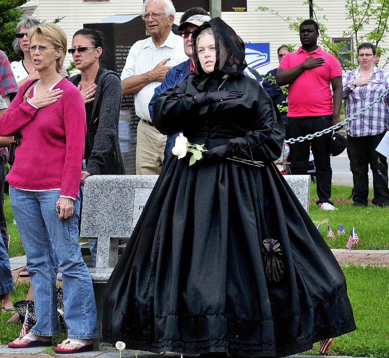 MOURNING: Dressed as a widow of a fallen soldier for all wars a woman who identified herself as Miss Rose recites the Pledge of Allegiance with others during a Memorial Day service at Veteran's Park in Skowhegan on Monday.