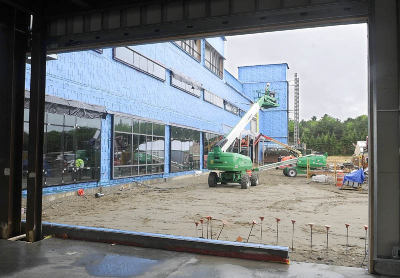 Workers on lifts are framed in a window of MaineGeneral's new regional hospital under construction in North Augusta.