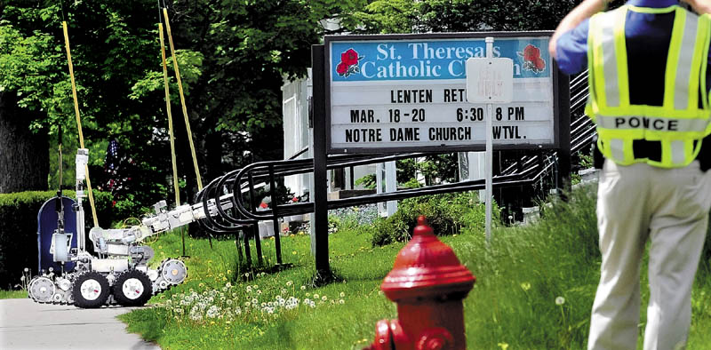 SUSPICIOUS: A Maine State Police remote-controlled robot approaches the steps in front of St. Theresa’s Catholic Church in Oakland on Wednesday after an object believed to be a pipe bomb was discovered. The robot detonated the object, which turned out not to be an explosive device.