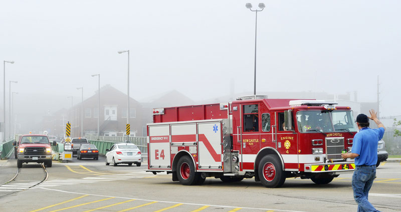 A shipyard worker thanks firefighters from New Castle, New Hampshire, as they leave the Portsmouth Naval Shipyard early Thursday morning following a fire overnight in the USS Miami, a nuclear submarine that was in for repairs.