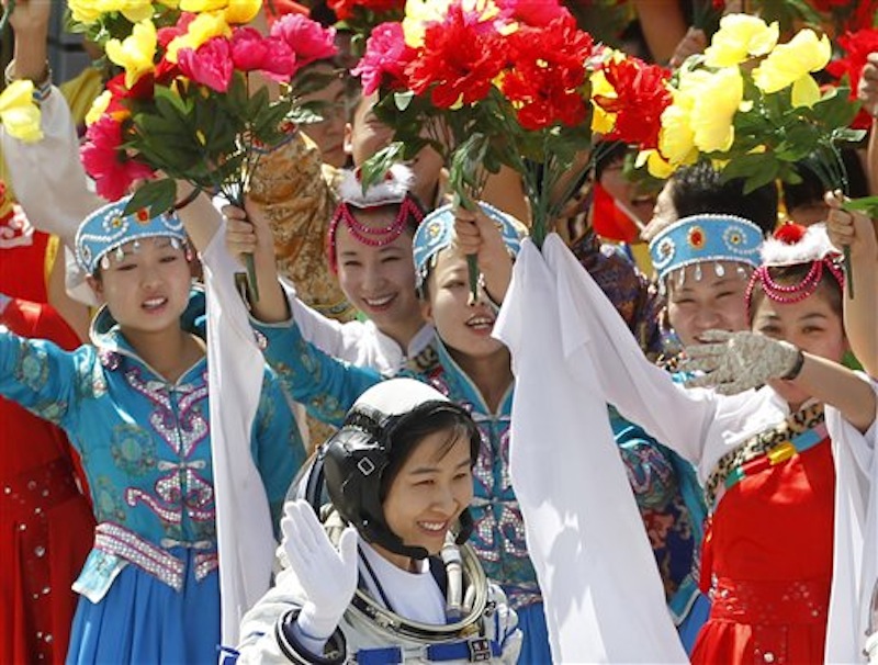 China's first female astronaut Liu Yang, bottom, waves during a sending off ceremony as she departs for the Shenzhou 9 spacecraft rocket launch pad at the Jiuquan Satellite Launch Center in Jiuquan, China, Saturday, June 16, 2012. China will send its first woman and two other astronauts into space Saturday to work on a temporary space station for about a week, in a key step toward becoming only the third nation to set up a permanent base in orbit. (AP Photo/Ng Han Guan)