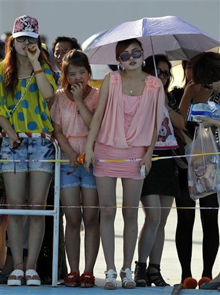 Spectators gather to watch the Shenzhou 9 spacecraft rocket launch from the Jiuquan Satellite Launch Center in Jiuquan, China, Saturday, June 16, 2012. China sends its first woman and two other astronauts into space Saturday to work on a temporary space station for about a week, in a key step toward becoming only the third nation to set up a permanent base in orbit. (AP Photo/Ng Han Guan)