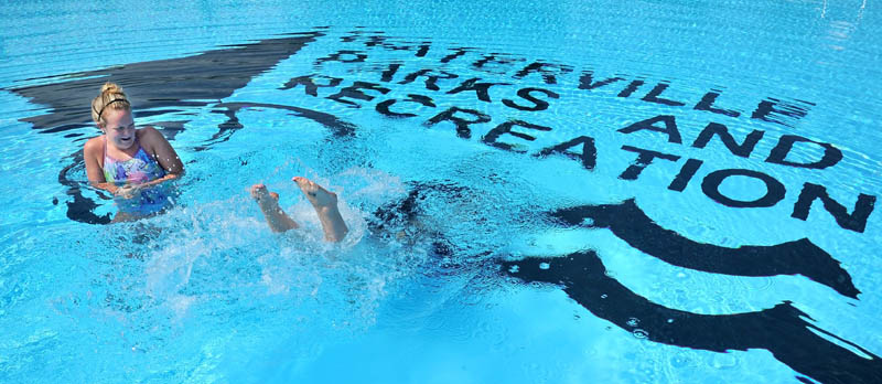 COOLING OFF: Allison Scully, left, watches as Natasha Morris dives into the pool at the Waterville Parks and Recreation swimming pool on North Street Thursday during lifeguard training.