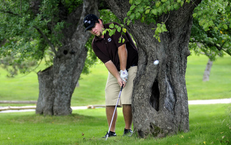 FIND AN OPENING: Ryan Gay of Pittson putts between two apple trees during the pro-am tournament of the Charlie’s Maine Open on Monday in Manchester.
