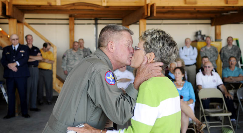 Eugene Richardson kisses his wife, Pam, on Monday after he was recognized for 50 years of safe aviation at the Civil Air Patrol hangar in Augusta.