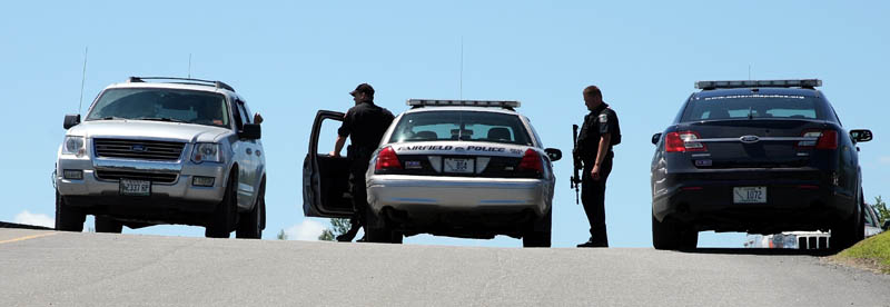 AT THE SCENE: Police officers stand in the parking lot next Kennebec Valley Council of Governments building in Fairfield after the Rite Aid on Main Street was robbed Friday.