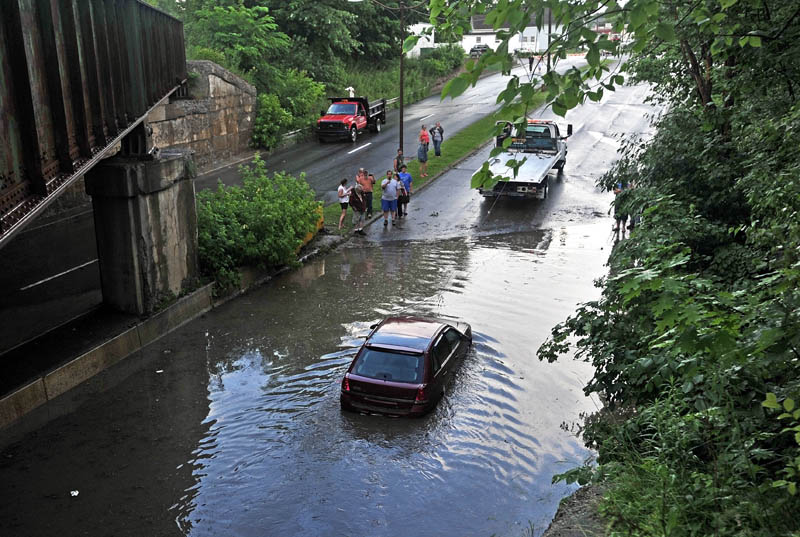 Staff Photo by Michael G. Seamans A car on upper Main Street in Fairfield is towed away Friday evening after a fast moving storm blew through the area.