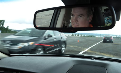 Professional test driver J.D. Ellis demonstrates the dashboard warning signal in a Ford Taurus, at an automobile testing area in Oxon Hill, Md.