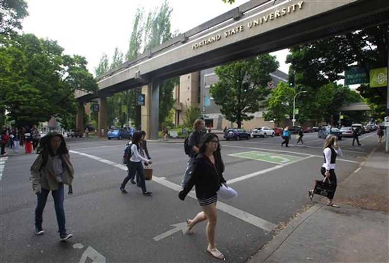 People walk along the Portland State campus Friday, June 1, 2012, in Portland, Ore. The State Board of Higher Education has increased tuition at Oregon's seven universities by an average of 6 percent for next school year. The increase approved Friday will be offset somewhat by cuts in fees. The increases range from 1.5 percent at Western Oregon University to 9.9 percent at Southern Oregon University. Because of fee cuts, total tuition and fees would actually fall at Western Oregon and Portland State. At the University of Oregon, the state's most expensive public university, a proposed 6 percent increase would push the cost of tuition and fees for undergrads to more than $9,300. The system average would be $7,841. (AP Photo/Rick Bowmer)