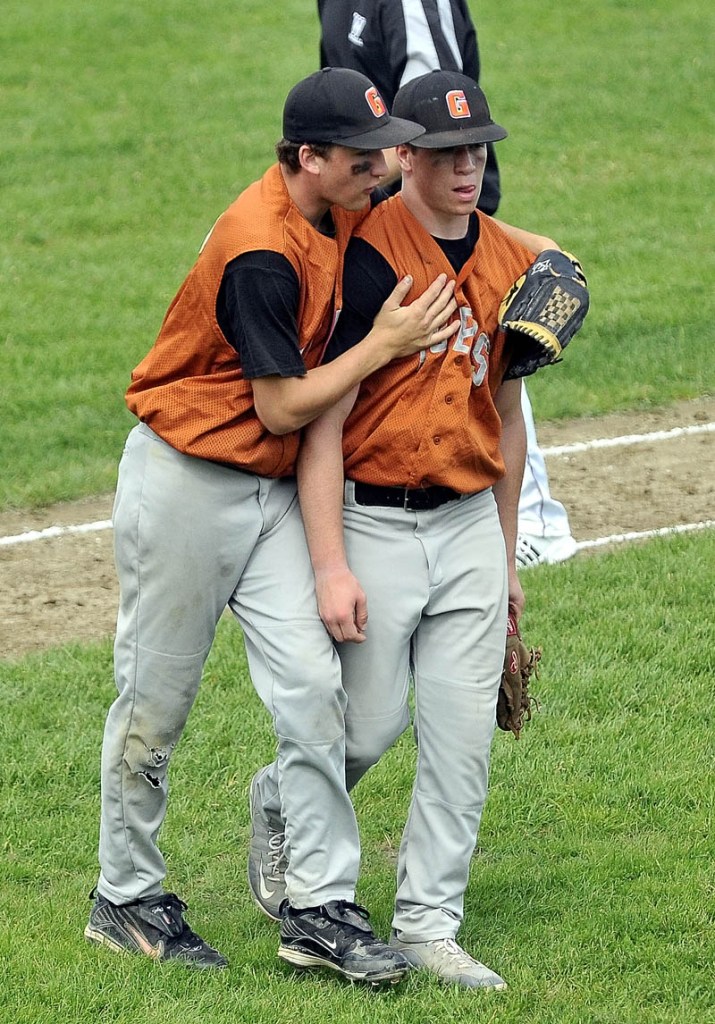 Staff Photo by Michael G. Seamans Gardiner High School left fielder Brandon Chaput, 5, left, comforts teammate relief pitcher Dennis Meehan, 2, right, after the second inning of the Eastern Class B Regional quarter finals game at Waterville High School Thursday. Waterville defeated Gardiner 11-1.