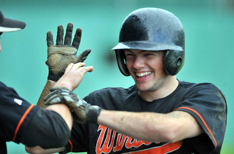 Staff Photo by Michael G. Seamans Winslow High School's Donnie Camp, celebrates with teammates after scoring in the third inning against Oceanside High School in the Eastern Class B preliminary game in Winslow.