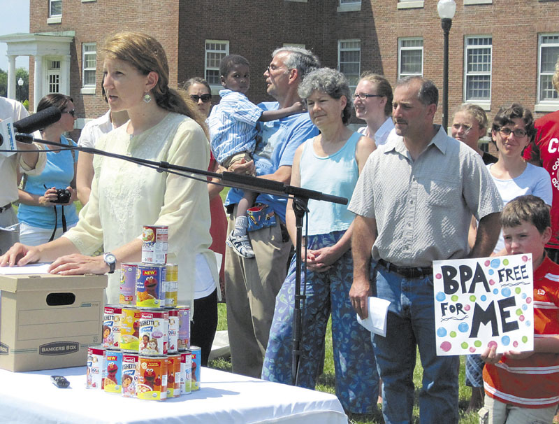 TOXIC TALK: Abigail King, the toxics policy advocate for the Natural Resources Council of Maine, talks about the dangers of bisphenol-A as 7-year-old Tyson Smith, right, holds a protest sign during a press conference Thursday in Augusta.
