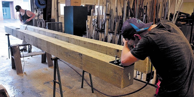 UNDER CONSTRUCTION: Carrabec High School students Kenneth White, left, and Anthony Toneatti work on support structures that will be part of an entry portico in front of the school on Tuesday.