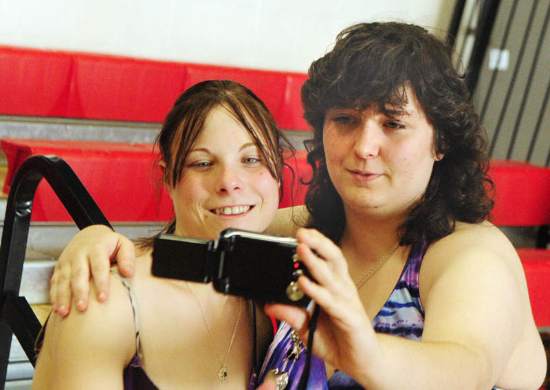 Loralai Dubord, left, gets her picture taken by her sister graduating senior Brittany Dubord before Hall-Dale High School graduation on Saturday evening at the school in Farmingdale.