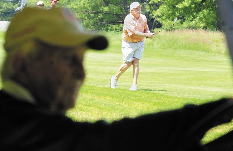 Staff photo by Joe Phelan Sitting a cart, Stan Plummer, 91, right, watches as his son Mark Plummer hits on fourth green on the first day of the Charlie's Maine Open Championship on Tuesday at the Augusta Country Club in Augusta.