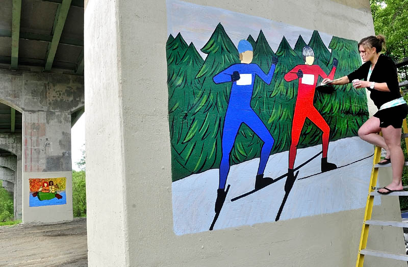 THE BIG PICTURE: Colby College graduate Kirsten Stray-Gundersen works on one of two large murals on columns under the I-95 bridge that goes over the Quarry Road Recreation Area in Waterville on Thursday.