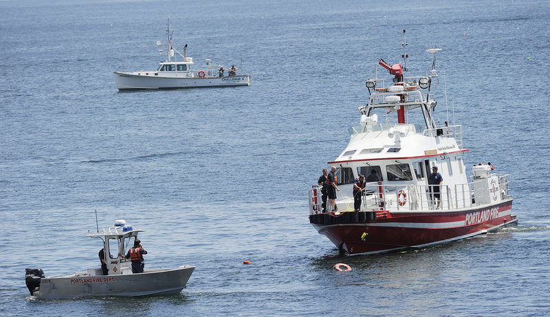 The Portland Fire Boat and other boats converge at the spot where a small plane plunged into Casco Bay on Sunday. Passing boaters pulled a man from the water, but he died.