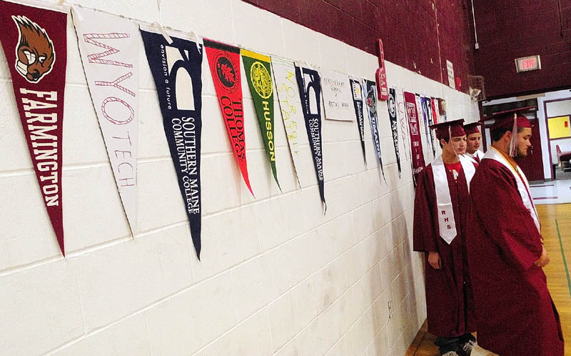 Seniors march in past a display where they'll be continuing their education next year, during graduation ceremony on Saturday afternoon at Richmond High School.