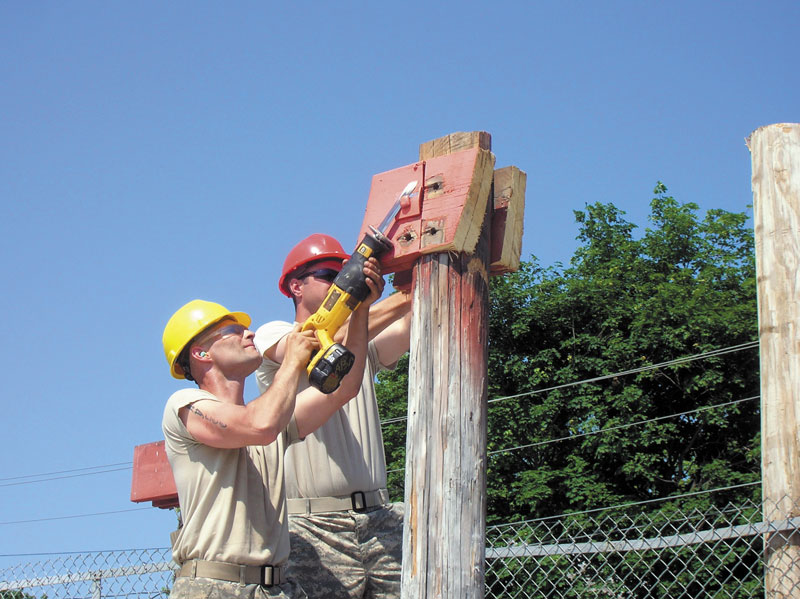 HARD AT WORK: Sargent Kevin Taylor, left, and Specialist Gene Bates, of the 136th Engineer Company of the Maine National Guard, work on the new press box at Winslow High School’s Poulin Field. The new structure will be completed this summer in time for the 2012 football season.