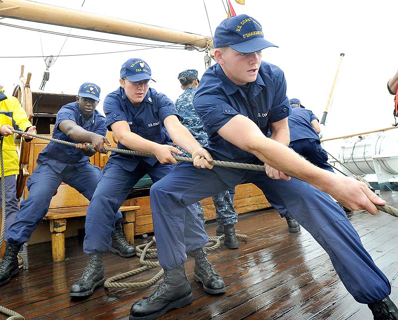 Raimon Henderson, Jallyn Harbison and Patrick O'Shaughnessy haul a line to a boom as the US Coast Guard Cutter Eagle enters Portland Harbor for a three day visit.