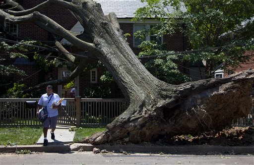 Giovanny Alvarez, a letter carrier for the U.S. Postal Service, delivers mail in Washington Monday, where a powerful storm swept through the region on Friday.