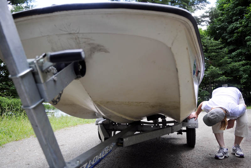 STOPPING THE INVASION: Maine Department of Environmental Protection environmental specialist Karen Hahnel, right, advises boaters to check both the underside of a boat and trailer for plants. The state agency is encouraging the boat checks before launching and after coming ashore with a boat to avert the spread of invasive species in Maine's water bodies.