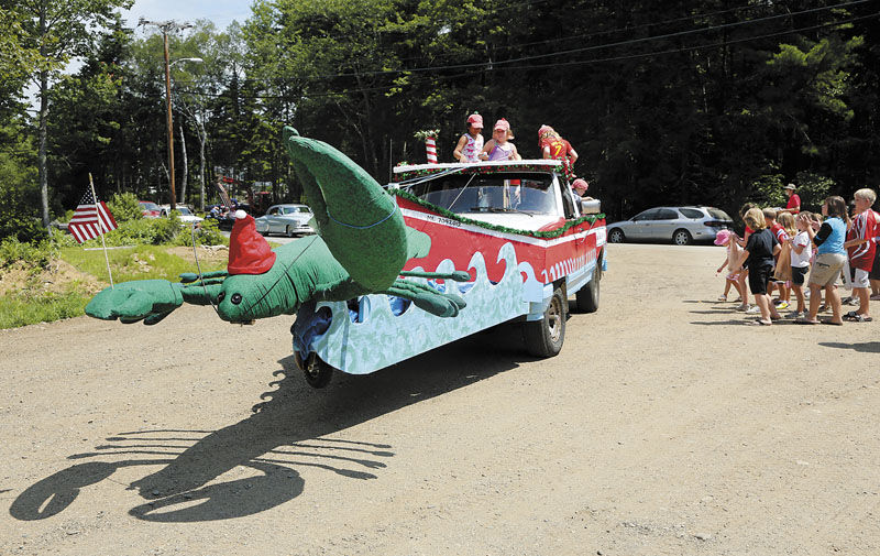 A truck decorated as a giant Christmas lobster is filled with children throwing candy and singing carols during the Chebeague Island Fourth of July parade.