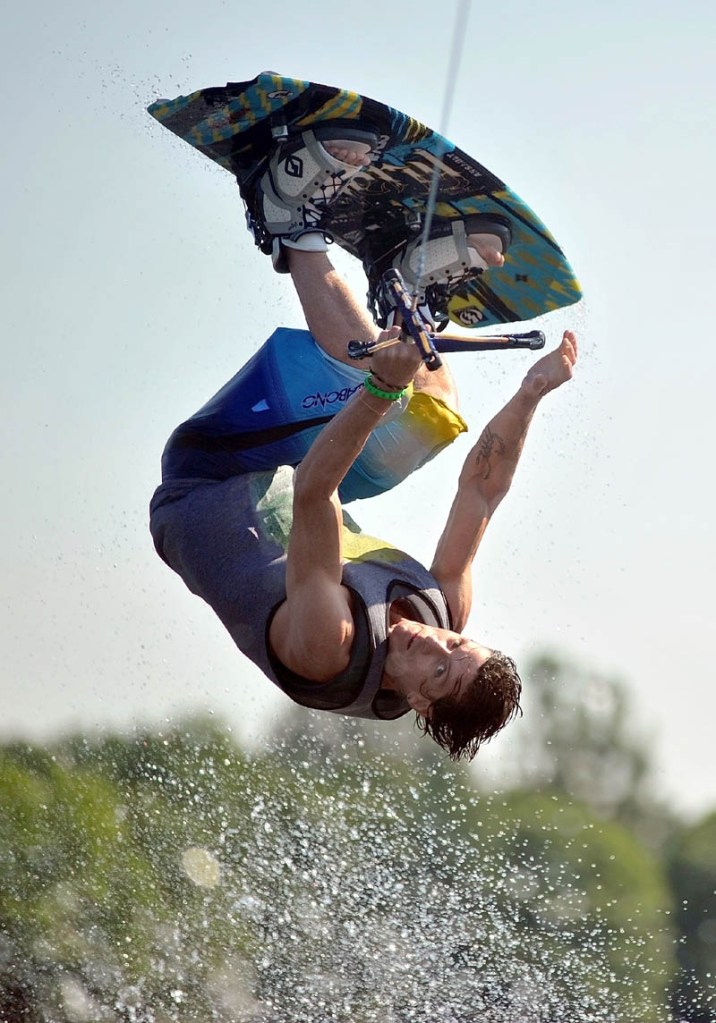 Staff Photo by Michael G. Seamans Troy Welch completes a full flip after jumping the wake on Messalonskee Lake in Oakland Friday morning.